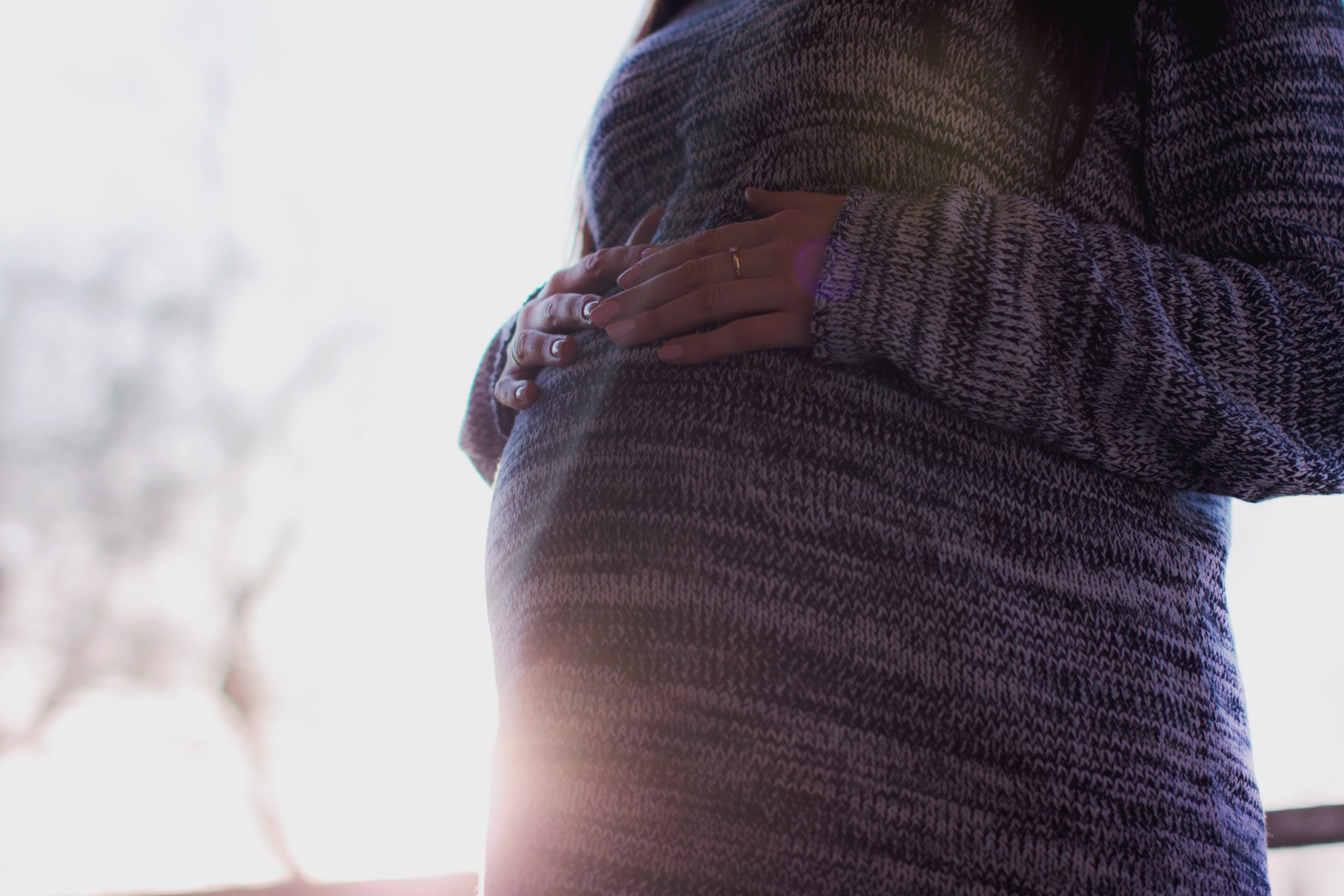 An expectant mother touches her bump